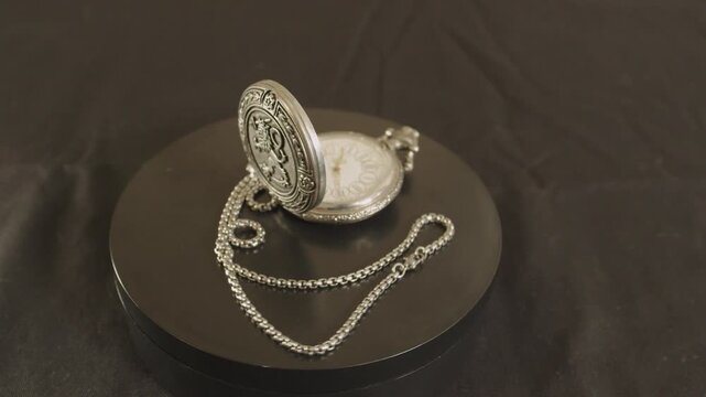 Antique silver pocket watch with its metallic chain.