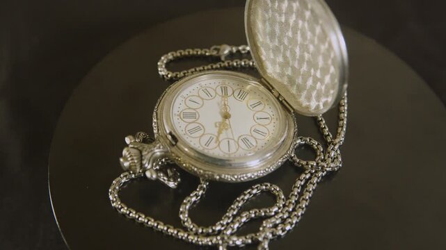 Metallic chain and silver case of a vintage watch.