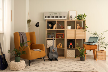 Interior of living room with guitar, armchair and shelf unit