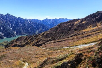 Obraz premium Vibrant Autumn Mountain Landscape with Alpine Lake and Distant Peaks, Tateyama, Japan