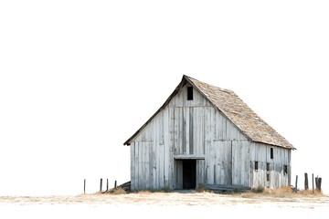 old weathered barn standing alone in a field with fence