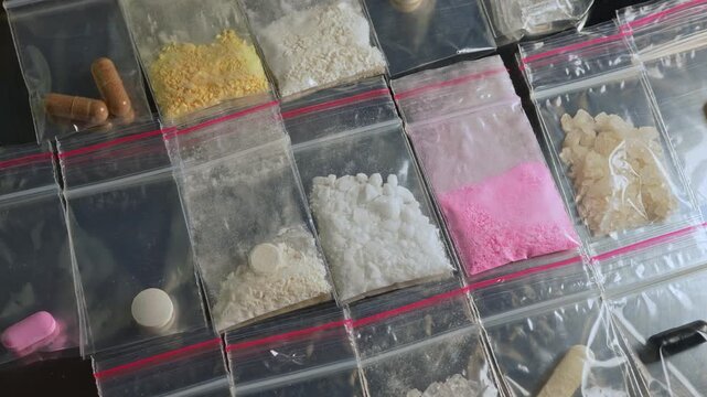 Fentanyl, nitazenes, heroin and synthetic opioid drugs smuggling displayed in small packages concept. Powder, crystals and capsules form causes severe drug crisis in the world.