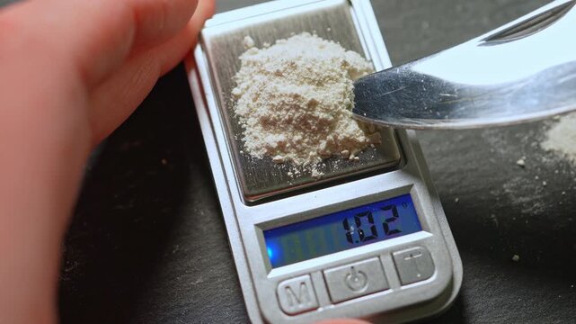 Synthetic opioid fentanyl drug being weighed on a mini scale for weight. Concept for mental health youth overdose in indigenous communities. Toxic drug opioid crisis and struggle with an addiction.