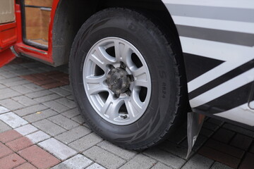 Close-up of car tire on brick pavement with silver rim