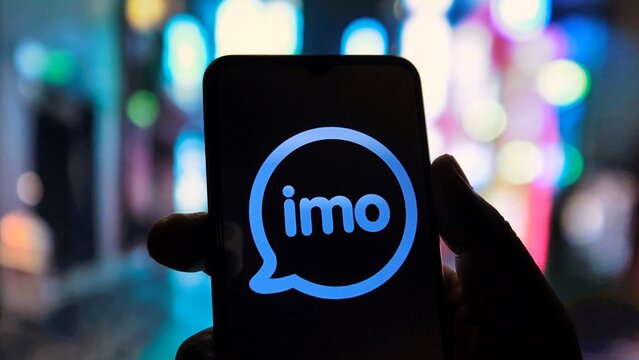 Hand holding smartphone with imo app logo on screen