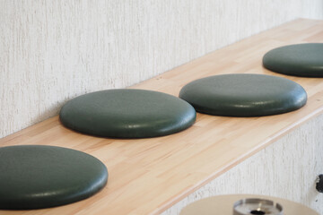 Seating pads arranged on a wooden shelf in a simple setting