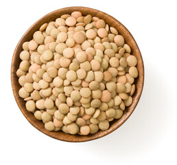 Uncooked brown lentils in the wooden bowl, isolated on white background, top view.