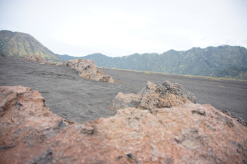 Rocky volcanic terrain and black sand sea at Mount Bromo National Park, Indonesia