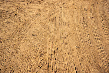 Tire tracks patterns on rural sandy road texture
