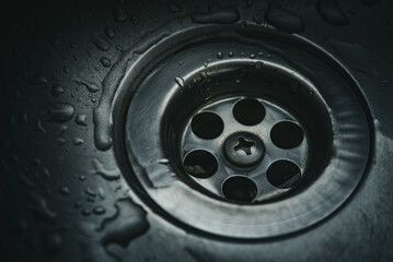 Water droplets on stainless steel kitchen sink drain