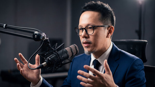 Male podcaster communicating, recording audio broadcast in studio