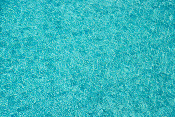 Vibrant blue water surface with shimmering reflections and ripples under sunlight