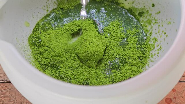 Pouring warm water into matcha bowl.