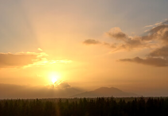 Scenic sunset with clouds, mountains, and forest in Southeast Alaska