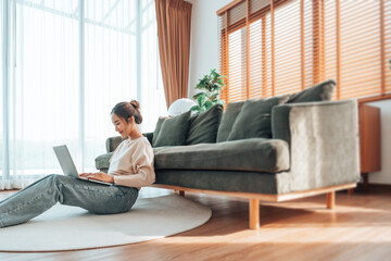 Young Asian beautiful woman relaxing on comfortable couch, using laptop at home, happy girl chatting with friends in social network, spending weekend, watching movie, shopping online