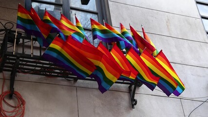 rainbow flags waving in window (symbol gay pride month celebration) west village manhattan new york city trans queer lesbian solidarity lifestyle alternative lifestyles advocacy struggle equality lgbt - Powered by Adobe