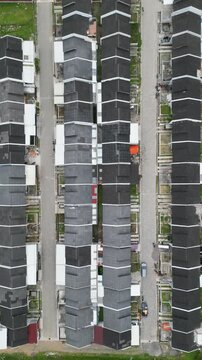 An aerial view of housing development in Wonosobo, showing neat rows of newly built homes, quiet streets, green open land, and a growing residential area blending with the surrounding landscape.
