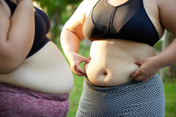 Midsection of a plus-size woman exercising outdoors in a park