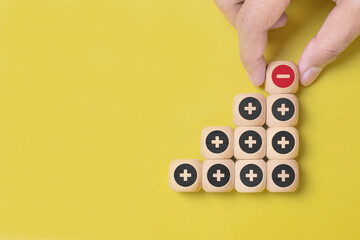 Plus and minus icons on wooden cubes. Separate the negative from positive, removing the weaknesses or negativity, positive thinking, negative feedback or subtraction