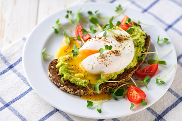 Healthy breakfast - Toast with avocado and egg on rye bread, selective focus.