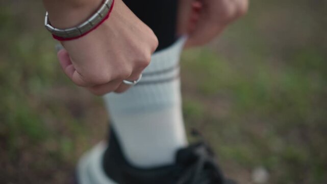 Sportsman Readying For Running Event, Preparation Scene Of Athlete Adjusting Socks And Accessories On Track, Closeup Of Sports Participant Fixing Socks And Jewelry Before Sprint Initiation