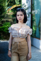 Cute Asian woman wearing glasses in a model-like style at a caf&eacute;