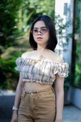 Cute Asian woman wearing glasses in a model-like style at a caf&eacute;