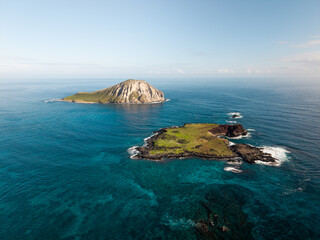 Aerial drone footage moving toward small tropical islands surrounded by clear blue ocean, showcasing rugged coastline, turquoise water, and remote island seascape in a peaceful natural environment © Bpato Media