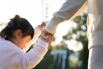 Mother and daughter holding hands outdoors, Mom hand lead his kid walking together. Family. Childhood development and growth with love for child, caring mom, happy family kid dream, support