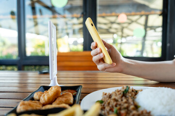 Woman use smartphone to scan QR code to pay in cafe restaurant with a digital payment without cash. Choose menu and order accumulate discount. E wallet, technology, pay online, credit card, bank app.