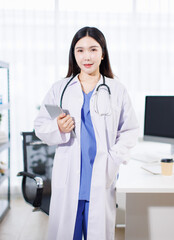 Portrait confident asian professional female doctor wearing white coat stethoscope standing holding tablet computer in clinic office hospital modern healthcare medical technology services consultation