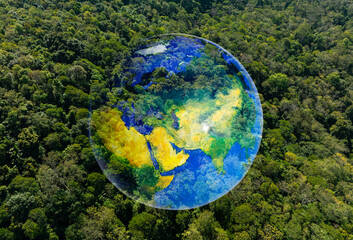 Aerial view of planet Earth globe superimposed on lush green tropical forest with white clouds, environmental conservation and global sustainability concept.