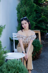 Cute Asian woman wearing glasses in a model-like style at a caf&eacute;