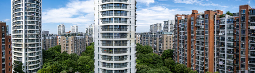 Panorama of modern high-rise residential apartment towers forming a compact city housing cluster in China. High-density urban living showing contemporary housing and vertical city growth. © Doublelee
