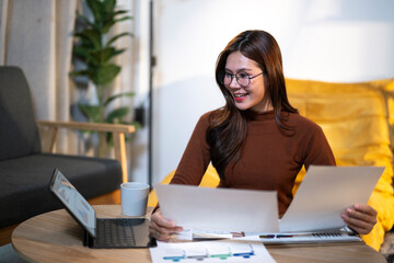 Asian woman working home office with documents