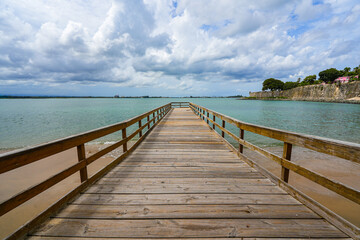 Fototapeta premium Wooden pier on the beach of the Puerta de San Juan in Puerto Rico - Coastal colonial fortifications in the Caribbean Sea