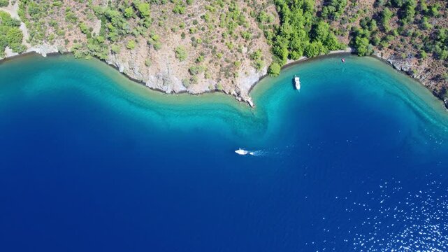 T&uuml;rkiye. A bird's-eye view of the sea. A view of the harbor with numerous yachts, sailboats, clear blue water, a beach, and mountains. Green hills and turquoise water. The Turkish Riviera.Dron.4K