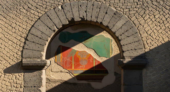 Ancient Roman fresco fragment and stone archway in Herculaneum,