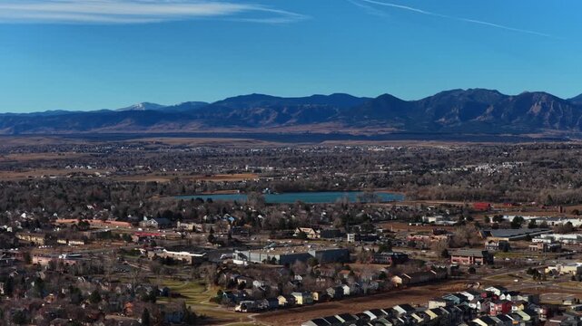 December winter morning Lafayette Erie Boulder Colorado Flat Irons Front Range Rocky Mountains cityscape cars traffic business buildings sunny blue sky foothills Boulder County University town static