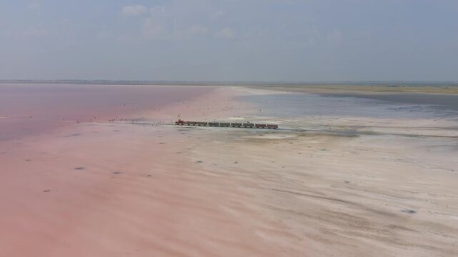 Burlinskoye Lake (Bursol), Altai Krai &mdash; Pink Salt Lake. A train‑like vehicle moves along the shore.