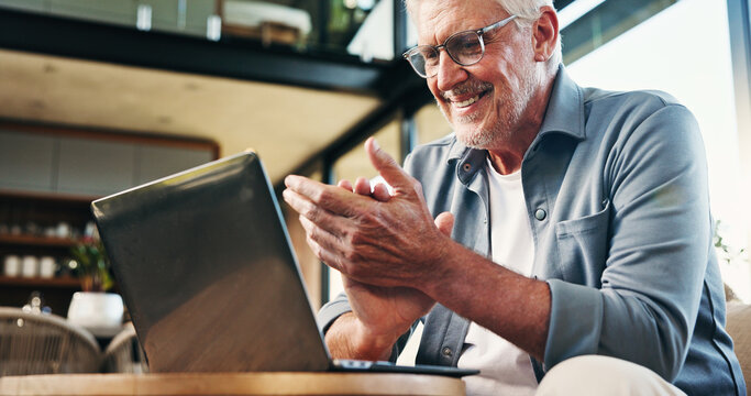Laptop, clapping and senior man on sofa in home with internet banking for investment payout. Celebration, computer and elderly person with online account for pension funds in living room at house.