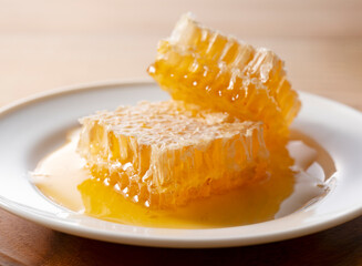 Fresh Raw Honeycomb on White Plate with Dripping Honey