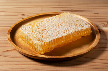 Fresh Honeycomb on Wooden Plate on Rustic Wooden Table