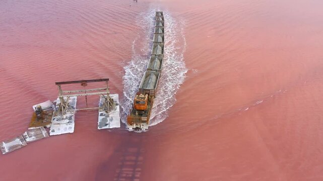 Burlinskoye Lake (Bursol), Altai Krai &mdash; Pink Salt Lake. A train‑like vehicle moves along the shore.