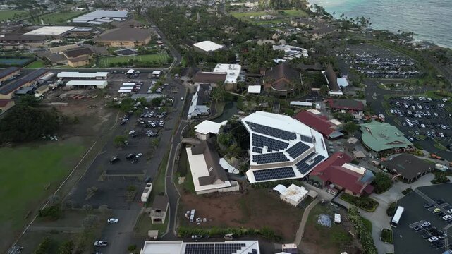 Drone aerial view of Polynesian Cultural Center surrounded by tropical village and coastline in Laie Hawaii USA
