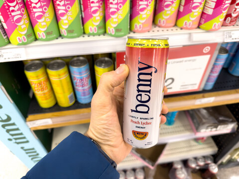 Benny Peach Lychee Canned Drink Held In Grocery Aisle