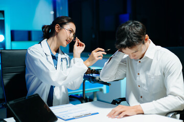 Asian female doctor consulting patient, taking medical history and explaining treatment in modern clinic