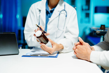 Closeup of doctor hands explaining a medicine bottle to a patient. Medical consultation, prescription guidance, healthcare, treatment,
