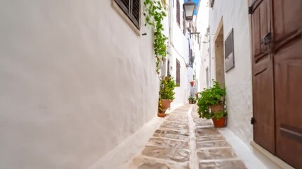 Bicycle parked in narrow white alley with brown shutters and basket