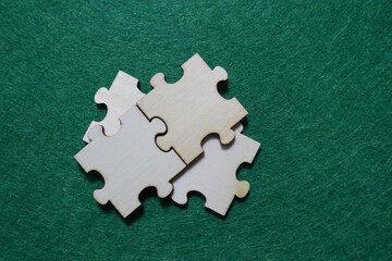 Obraz premium Three wooden puzzle pieces on a green surface